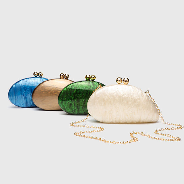 Ovale Hartschalen-Clutch mit marmorierter Perlmuttschimmer-Oberfläche, doppeltem Kugelverschluss in Goldoptik und Kettenriemen in Goldoptik, Detailansicht