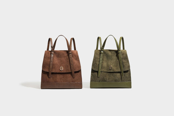 Structured suede-look convertible backpack handbag with flap closure and gold-tone emblem hardware in chocolate brown, detail