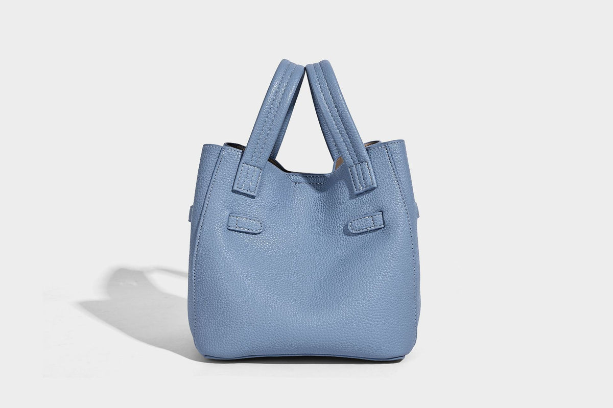Small structured pebbled bucket tote bag with dual top handles, silver turn-lock front pocket, and detachable shoulder strap