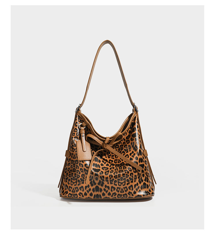 Slouchy leopard print shoulder hobo bag with black leather-look trim, tie-top closure, and single long strap, detail view 16