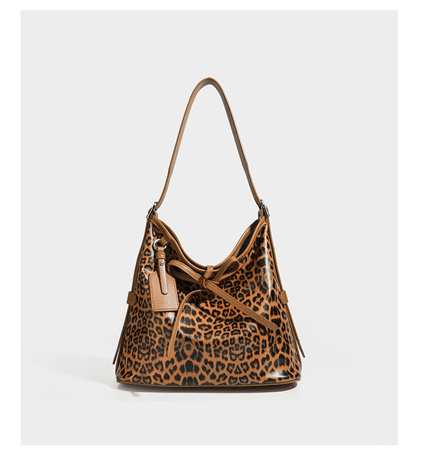 Slouchy leopard print shoulder hobo bag with black leather-look trim, tie-top closure, and single long strap, detail view 16