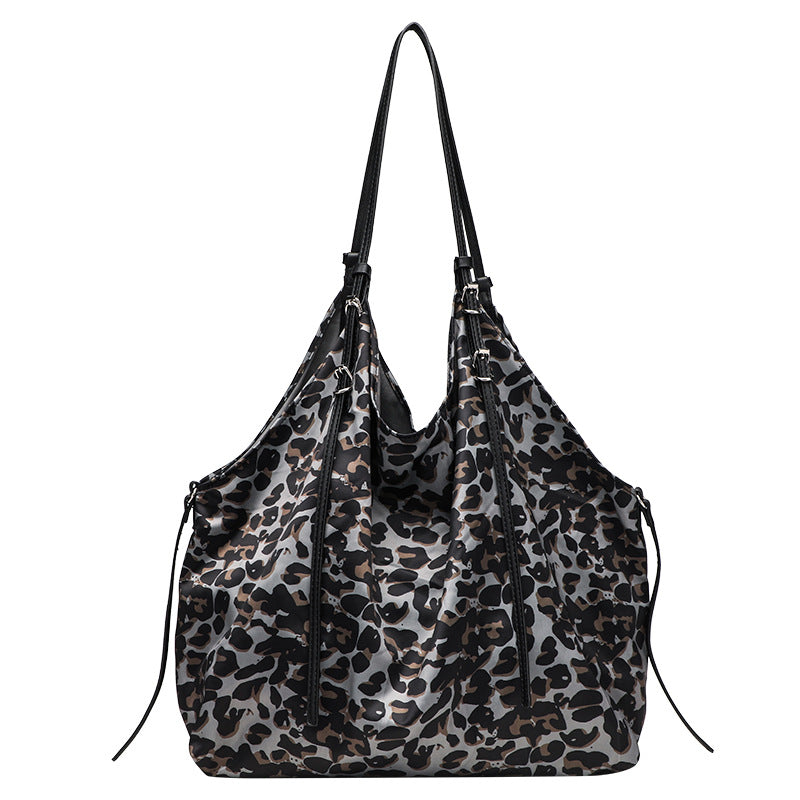 Large leopard-print slouchy tote shoulder bag in grey, black, and tan with gold-tone hardware and adjustable leather-look
