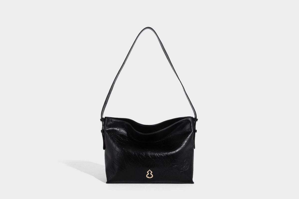 Large slouchy hobo shoulder bag in glossy crinkle leather-look finish with gold-tone emblem hardware and adjustable strap