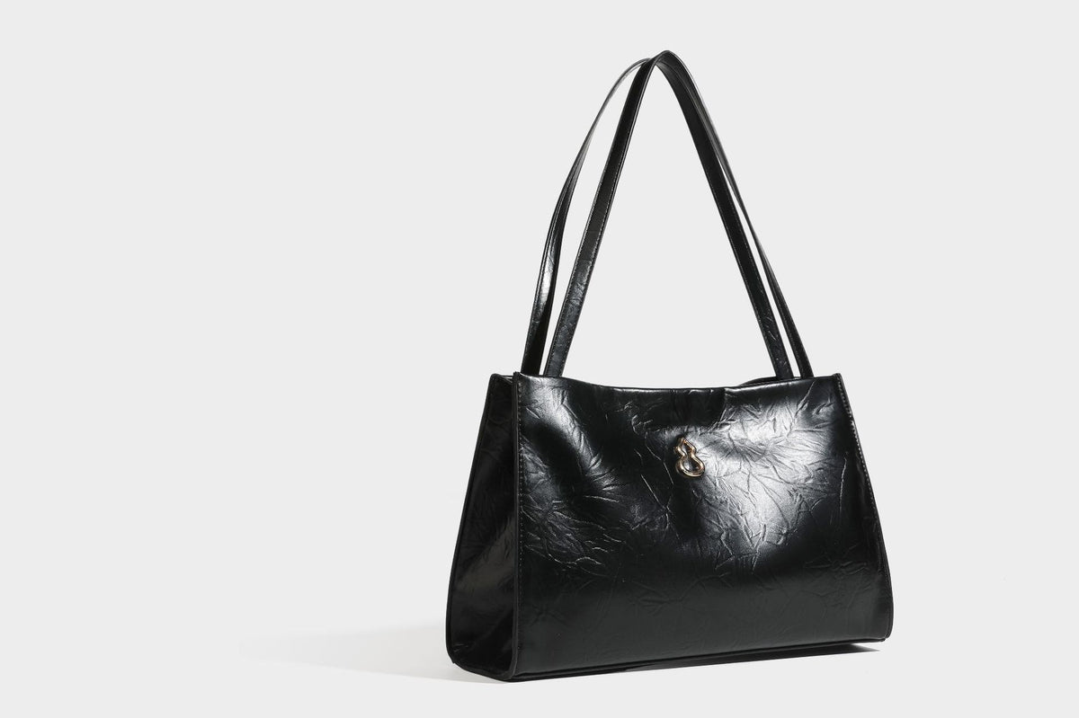 Strukturierte rechteckige Tote-Schultertasche aus glänzender, geknitterter Lederoptik mit langen Doppelträgern und Emblem in Goldoptik