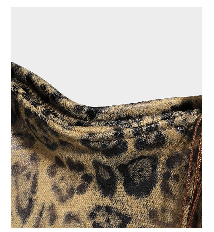Large leopard print shoulder tote bag in tan and brown with slim dark straps and dangling beaded charm hardware, detail view