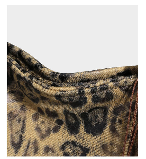 Large leopard print shoulder tote bag in tan and brown with slim dark straps and dangling beaded charm hardware, detail view