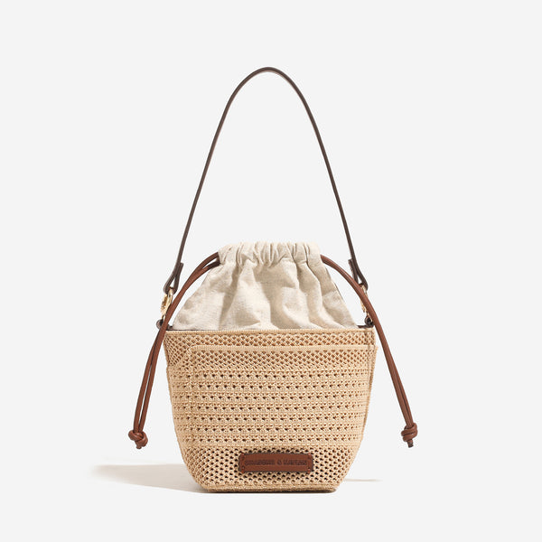 Compact openwork woven bucket bag with gathered cream drawstring liner, leather-look brown trim and cords, and gold-tone