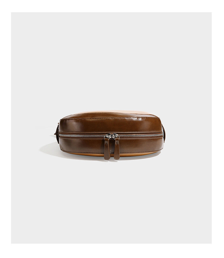 Glossy leather-look crescent hobo shoulder bag with dark contrast trim, silver-tone hardware, and attached mini flap pouch