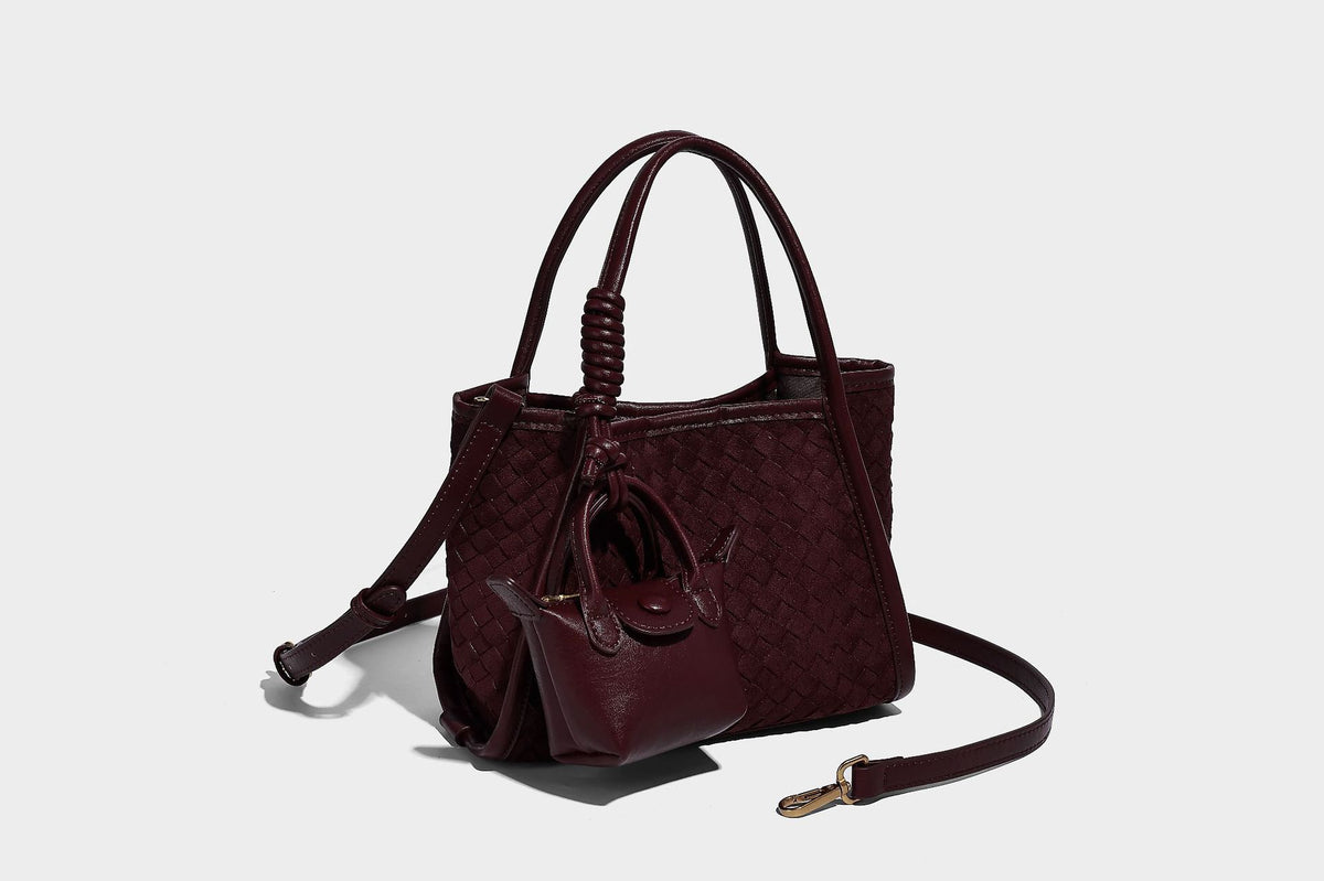 Strukturierte Tote-Bag mit gewebter Oberfläche, befestigtem Mini-Charm-Täschchen, geknoteten Tragegriffen und abnehmbarem Schulterriemen, Detailansicht