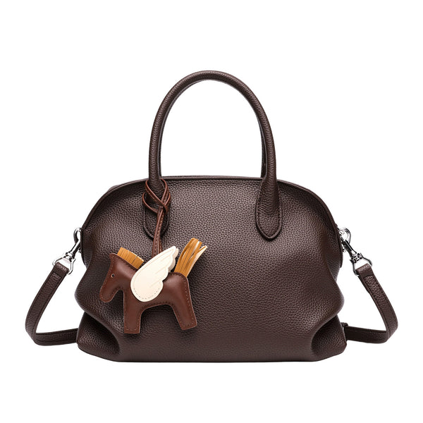 Rounded dome shell handbag in pebbled leather-look finish with twin top handles, zip closure, decorative horse charm, and