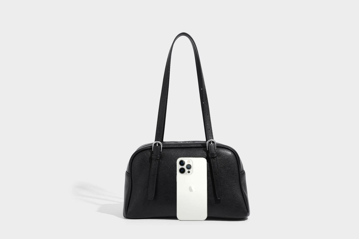 Structured dome-shaped shoulder bag with leather-look finish, top zipper closure, dual adjustable slim straps, and, detail