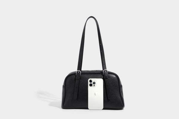 Structured dome-shaped shoulder bag with leather-look finish, top zipper closure, dual adjustable slim straps, and, detail