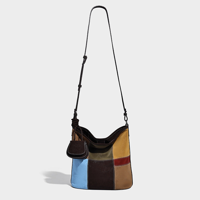 Lässig weich fallende Patchwork-Beuteltasche mit dunkelbraunen, cognacfarbenen, senfgelben, olivgrünen, roten und hellblauen Einsätzen sowie Kontrastnähten