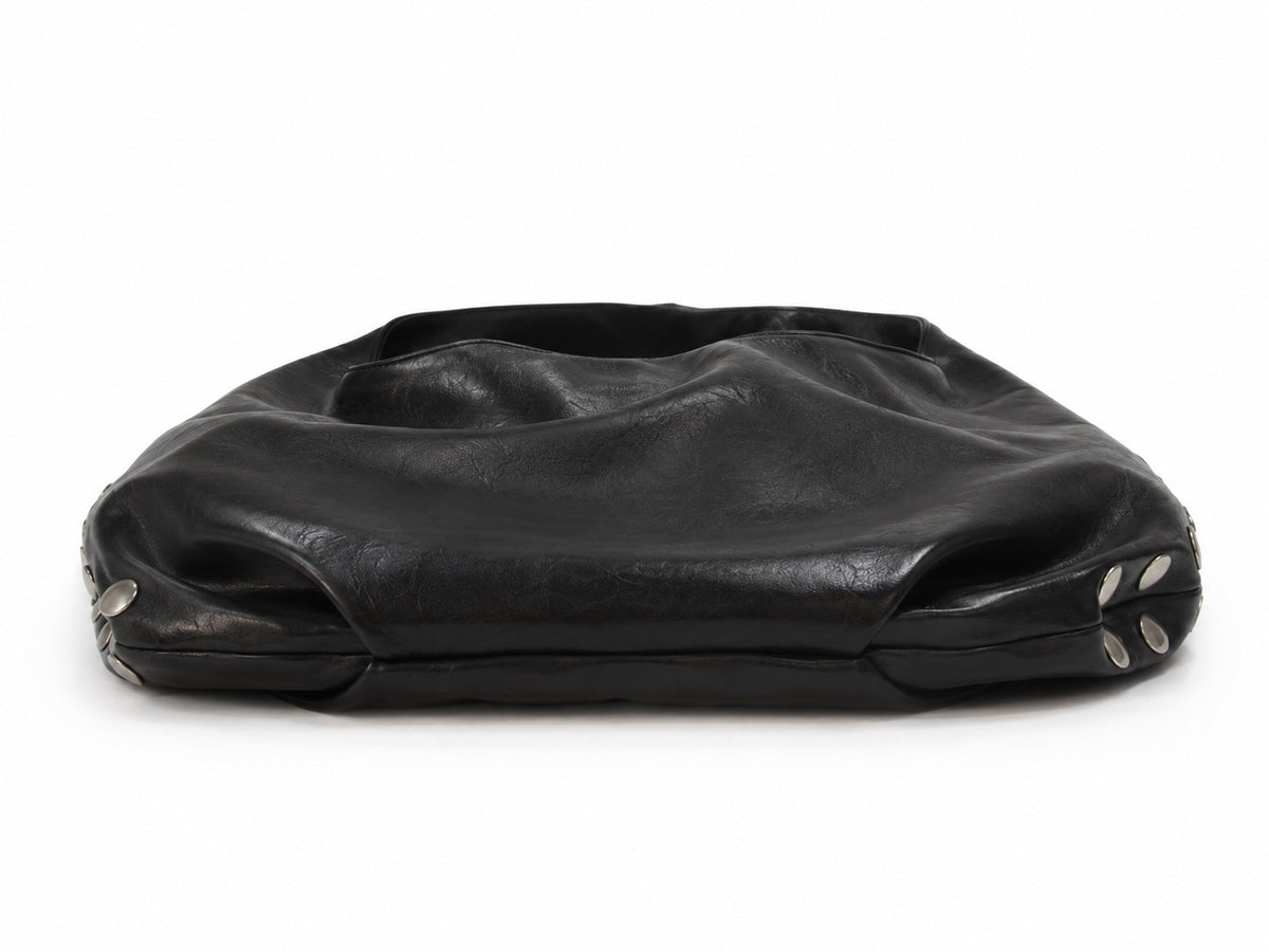 Schwarze Hobo-Bag in Lederoptik mit silberfarbenen Kuppelnieten entlang der Seitenaht und einem breiten einzelnen Tragegriff oben, Detail
