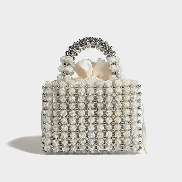 Small boxy pearl-bead mini top-handle bag with silver metallic bead accents, satin floral detail, and long beaded shoulder