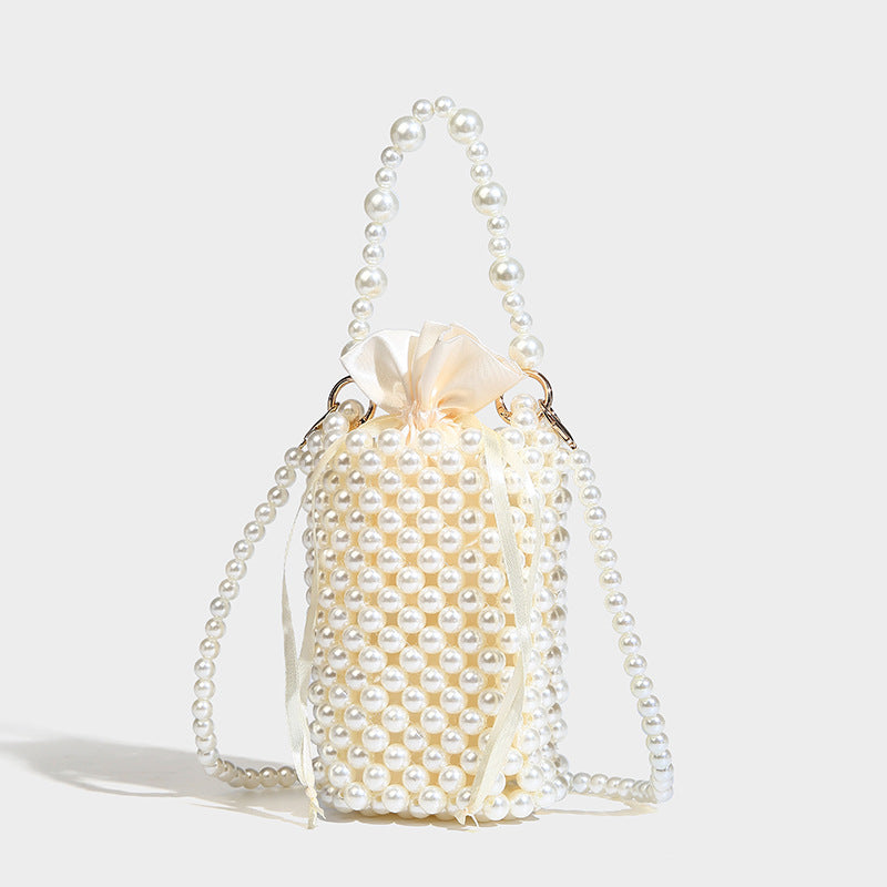 Mini cylindrical bucket bag covered in metallic silver beads with braided top handle and chain shoulder strap, detail view 2