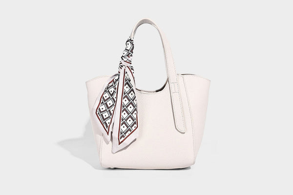 Structured pebbled leather-look tote bag with detachable scarf tie, dual top handles, and adjustable crossbody strap, detail