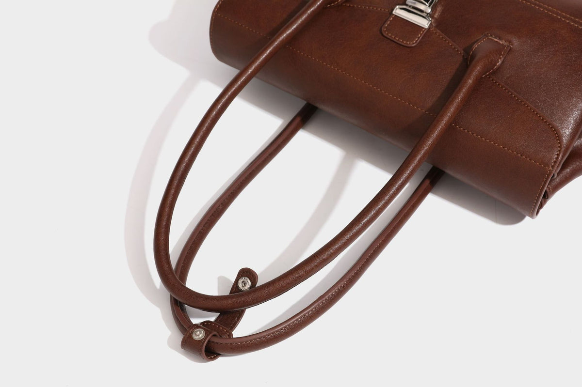 Structured rectangular satchel bag with dual rounded top handles and central metal turn-lock flap closure, detail view 23