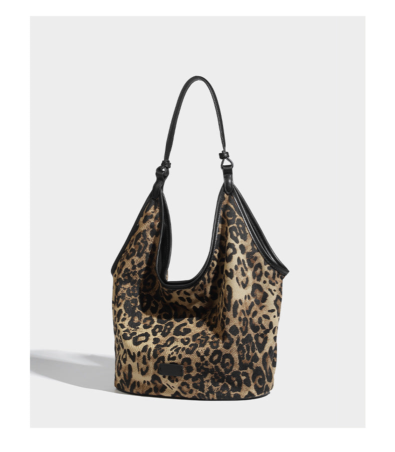Slouchy brown leopard jacquard hobo tote bag with black leather-look trim and single shoulder strap, shown with black, detail
