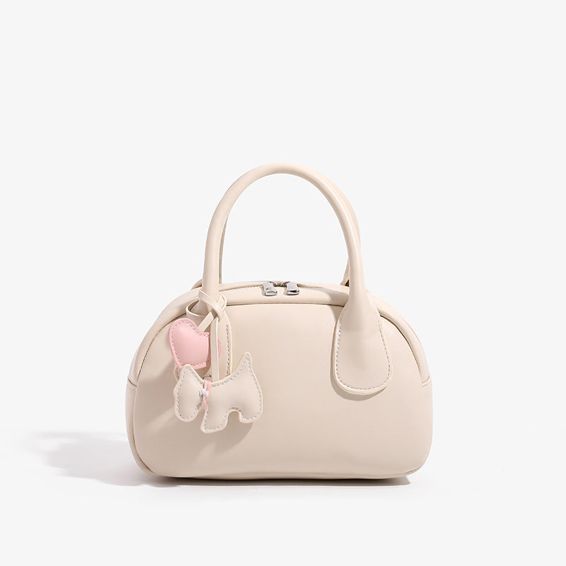Mini-Handtasche in Kuppelform mit glatter Oberfläche in Lederoptik, zwei Tragegriffen, Reißverschluss oben, Beschlägen in Silberoptik und herabhängendem