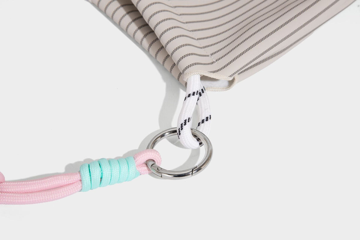 Slouchy pinstripe tote bag with braided rope handles, metal ring hardware, and colorful knotted rope charm, detail view 26