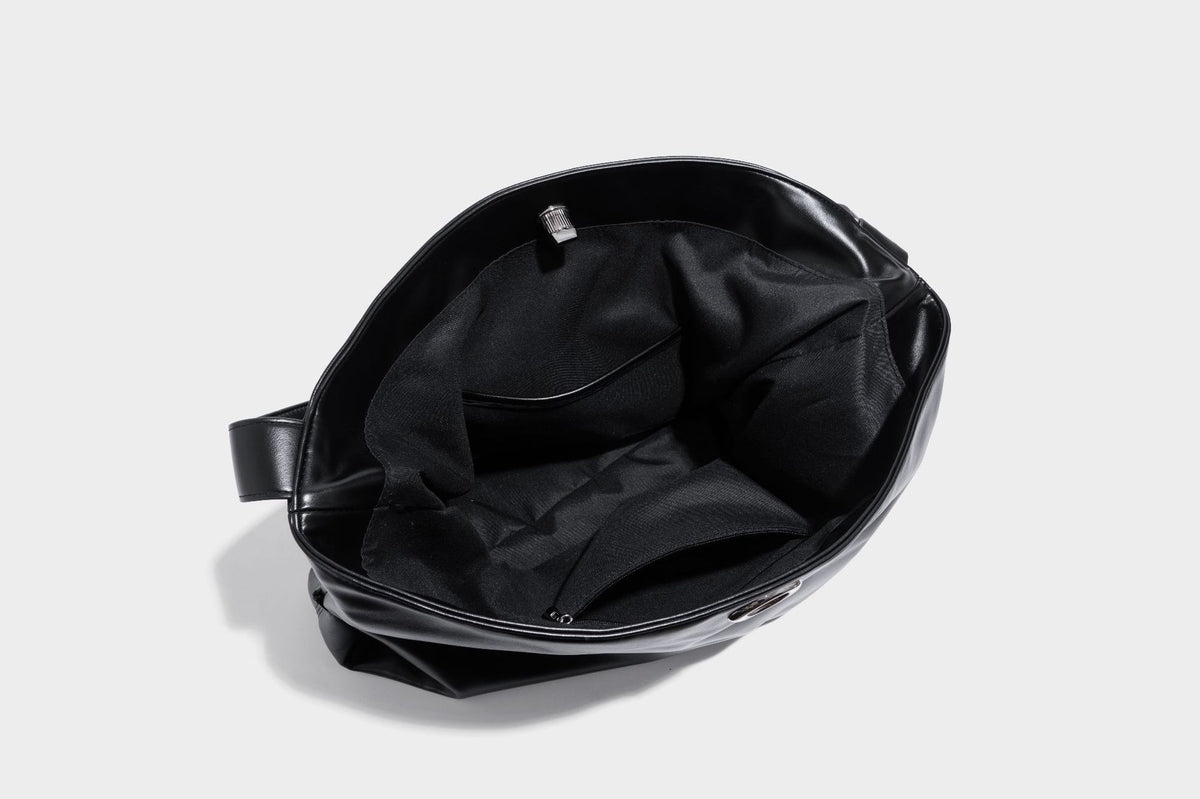 Große schwarze, glänzende Hobo-Schultertasche in Lederoptik mit mit Ösen besetztem Riemen, silberfarbenen Beschlägen und abnehmbarem