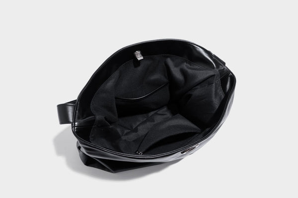 Große schwarze, glänzende Hobo-Schultertasche in Lederoptik mit mit Ösen besetztem Riemen, silberfarbenen Beschlägen und abnehmbarem