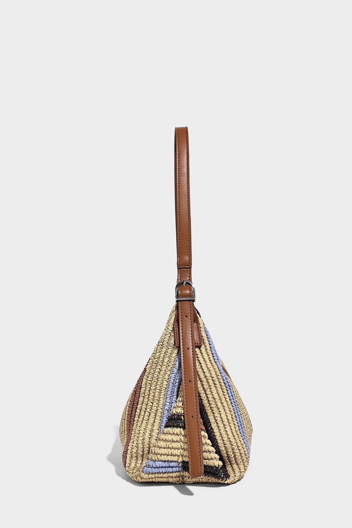 Slouchy woven straw hobo shoulder bag with beige, black, brown, and blue vertical stripes and brown leather-look trim, detail