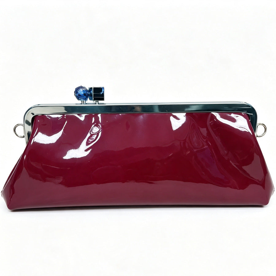 Strukturierte Clutch mit Kiss-Lock-Rahmenverschluss aus dunkelbrauner, krokodil-geprägter Lederoptik mit goldfarbenen Details und schmalem