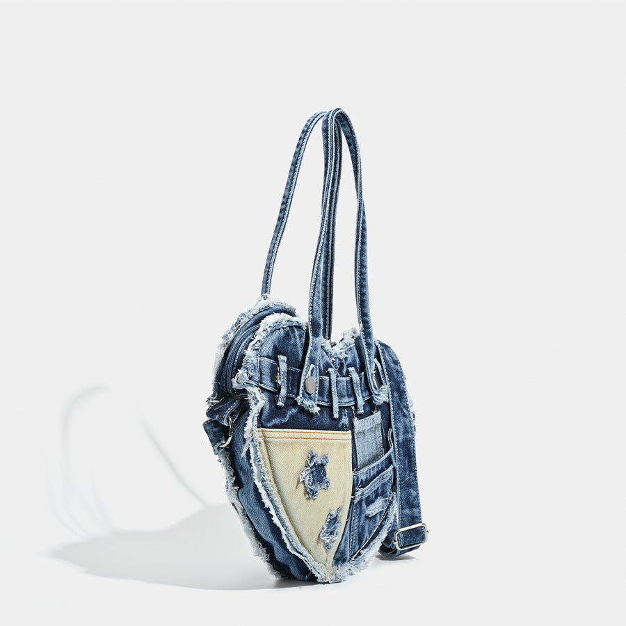 Heart-shaped patchwork washed denim shoulder bag with frayed edges, front patch pockets, and metal hardware, detail view 3
