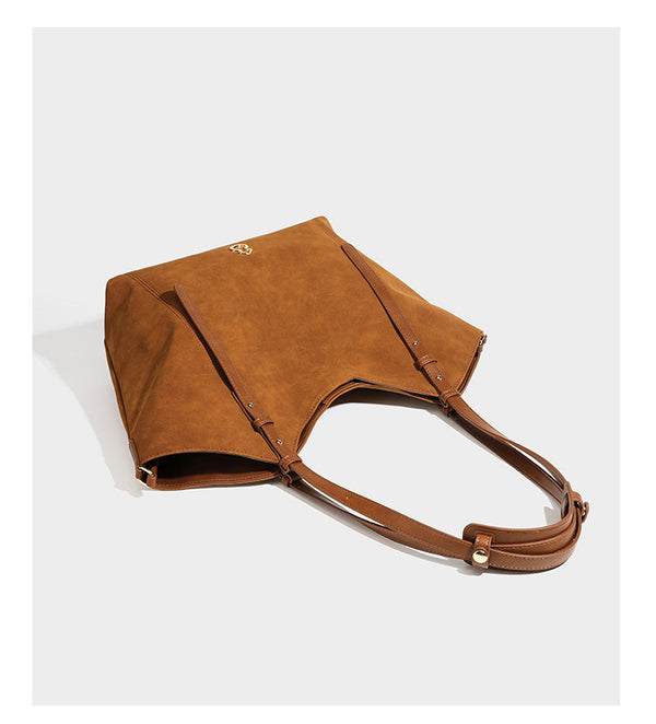 Oversized suede-finish tote shoulder bag in caramel brown with slim leather-look straps and gold-tone logo hardware, detail