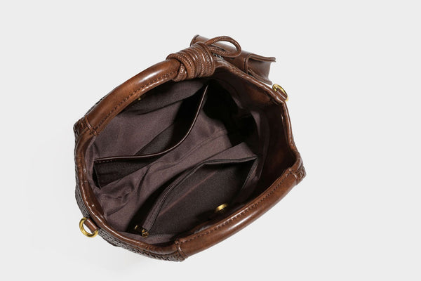 Woven leather-look tote bag in mocha brown with knotted top handle, front flap pocket, and detachable crossbody strap with