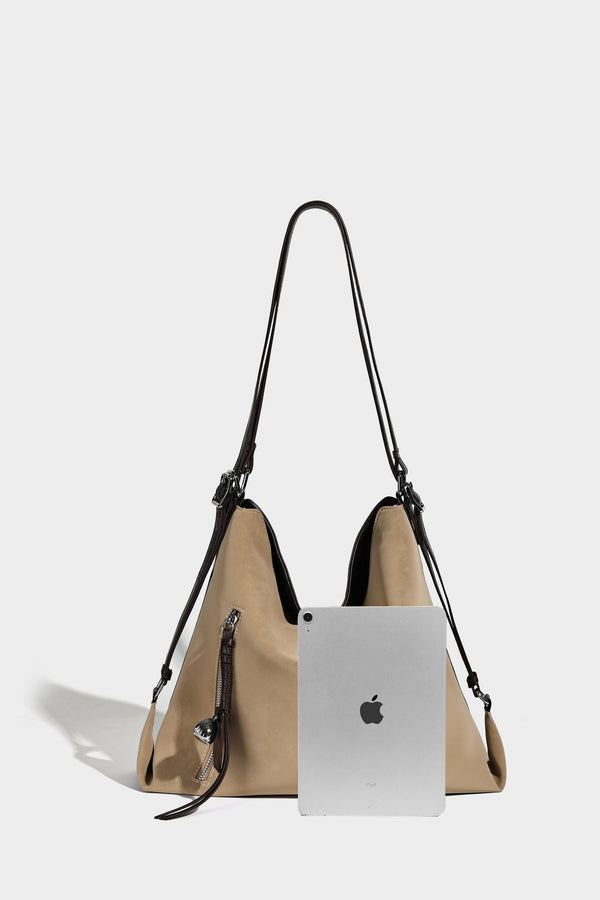 Slouchy hobo tote bag with matte leather-look finish, triangular silhouette, front zip pocket, and adjustable shoulder strap