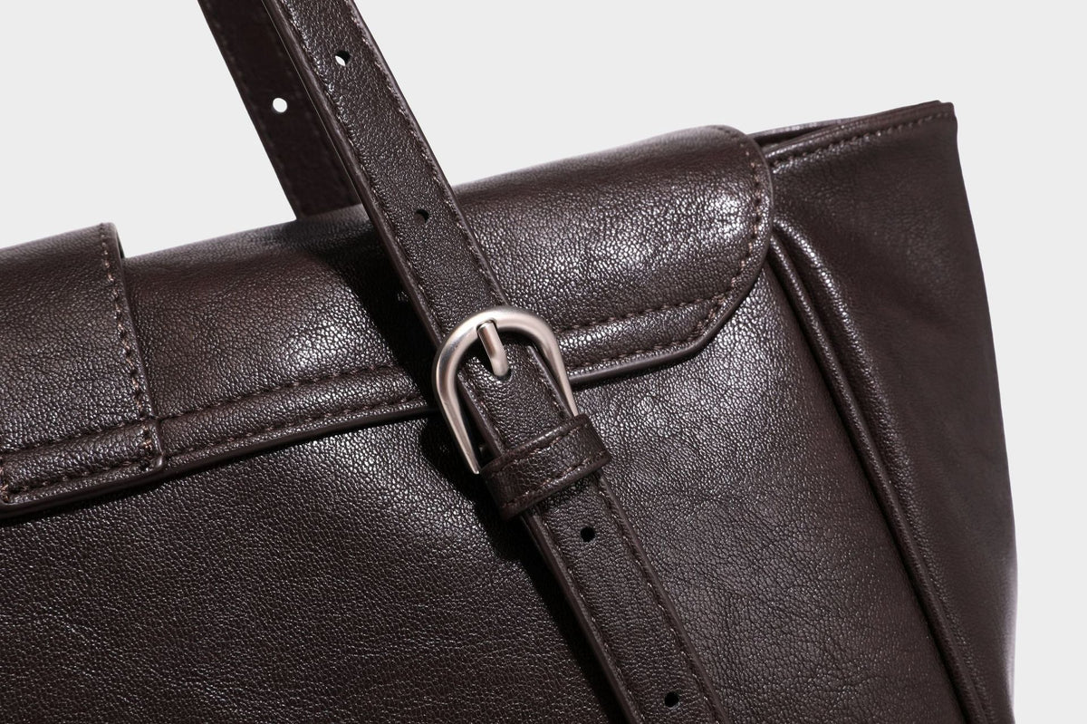 Large structured vintage-style tote bag with flap-front turn-lock closure, twin buckle straps, and double shoulder handles