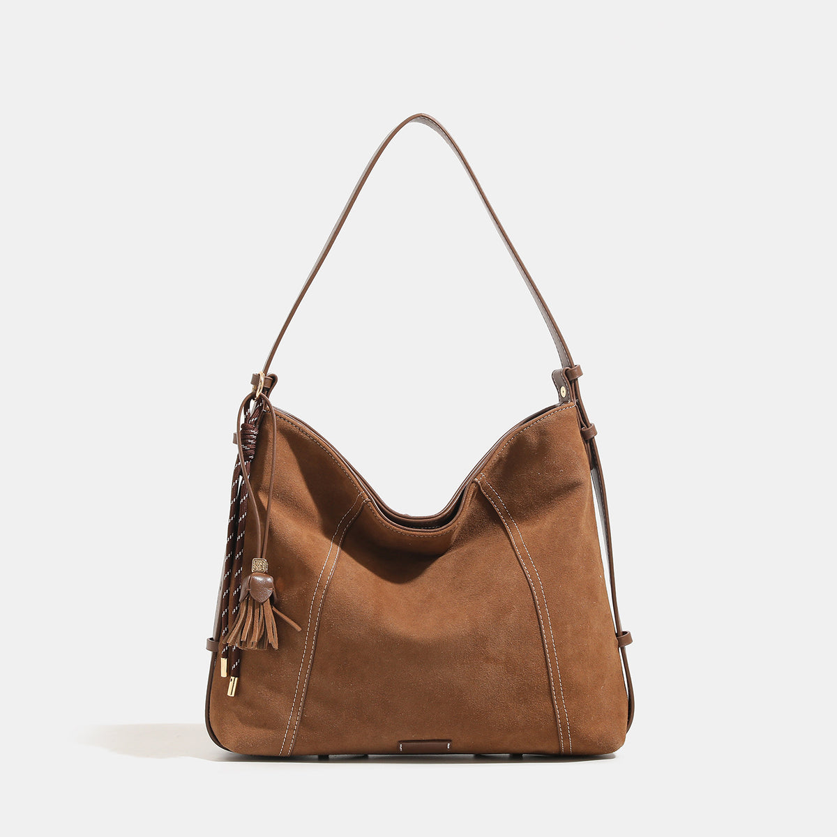 Slouchy suede-finish hobo shoulder bag in warm mocha brown with contrast stitching, braided tassel side accent, and, detail