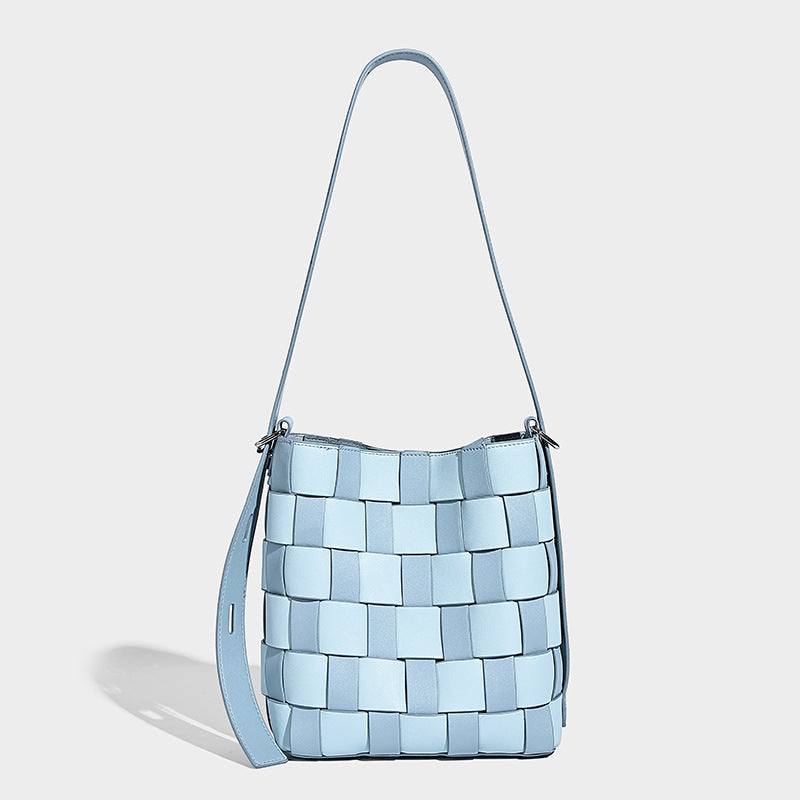 Hand-woven black-and-white checkerboard bucket bag with smooth black trim, silver-tone ring hardware, and adjustable