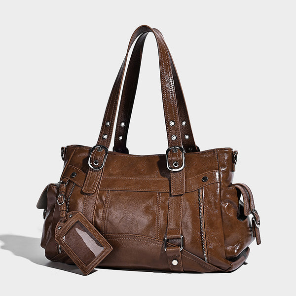 Glossy structured black tote shoulder bag with silver buckle hardware, zip pockets, dual top handles, and detachable, detail