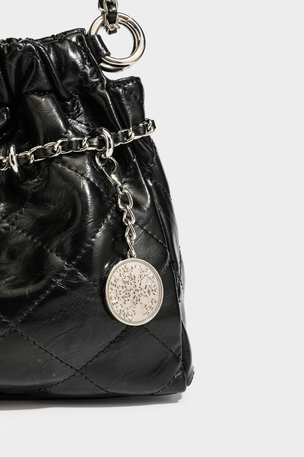 Glossy diamond-quilted drawstring bucket bag with silver chain shoulder strap and medallion charm, detail view 26