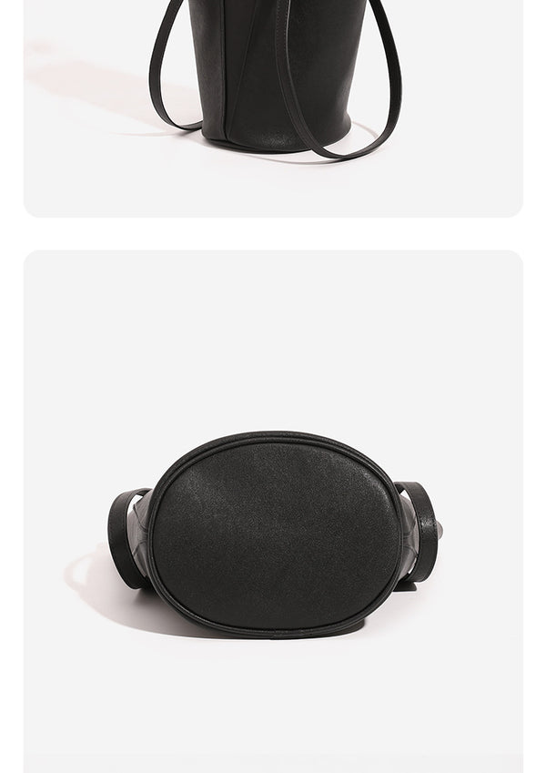 Structured black leather-look bucket tote bag with slim shoulder straps, silver-tone stud hardware, and tapered body, detail