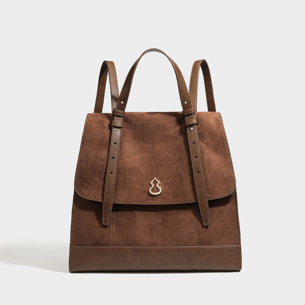 Structured suede-look convertible backpack handbag with flap closure and gold-tone emblem hardware in chocolate brown, detail