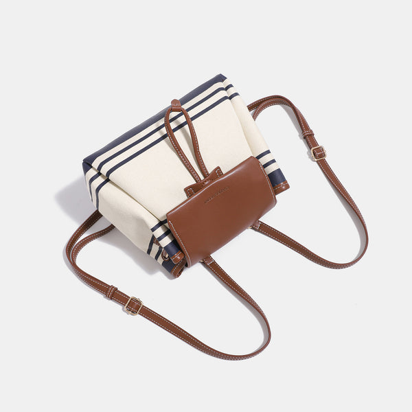 Cremefarbene Canvas-Beuteltasche mit marineblauen horizontalen Streifen, cognacfarbenem Kunstleder-Lappen und -Besatz, goldfarbenen Metalldetails und wandelbarer Trageweise