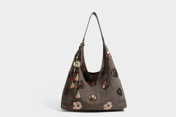 Lässig fallende, trapezförmige Schulter-Tote in Anthrazitgrau mit floralen Paillettenmotiven in Silber, Riemen in Lederoptik und herabhängendem Perlenbesatz
