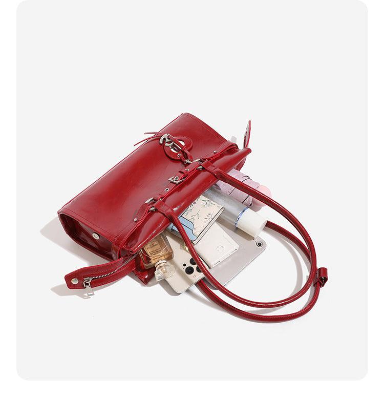 Glänzende, strukturierte rechteckige Schultertasche mit zwei Riemen, vorderem Riemen mit Gürtelschnalle, Herzanhänger und silberfarbenem