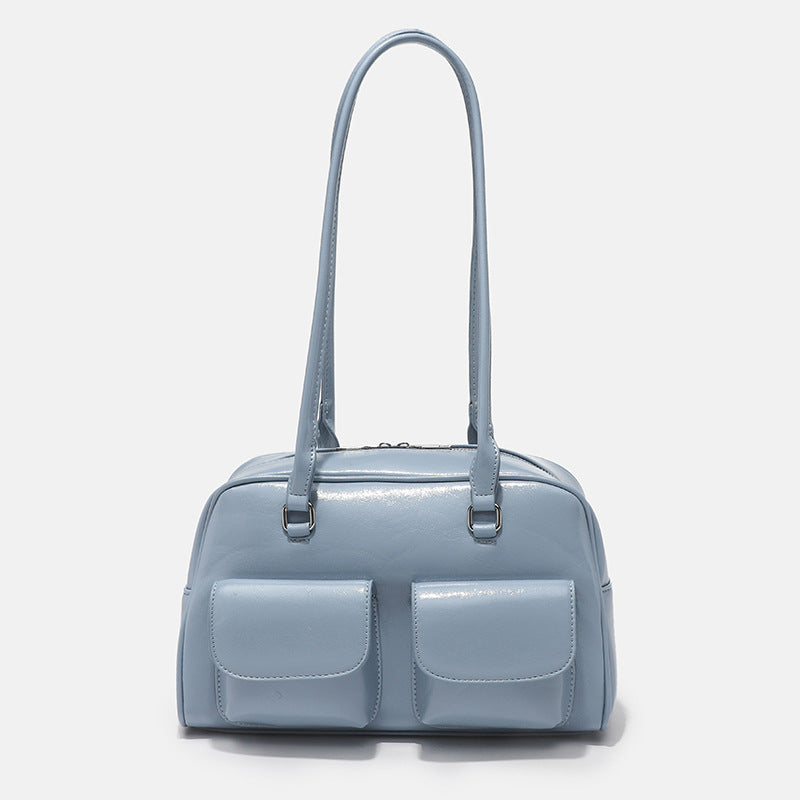 Structured glossy leather-look bowling shoulder bag with two front flap pockets, top zip closure, and long double shoulder