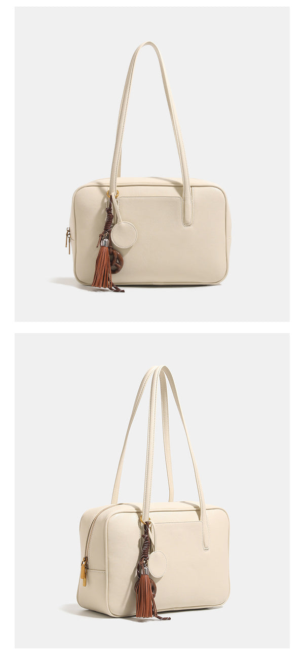 Structured rectangular leather-look shoulder bag with top zip, tassel and resin ring charm, and contrast topstitching, detail