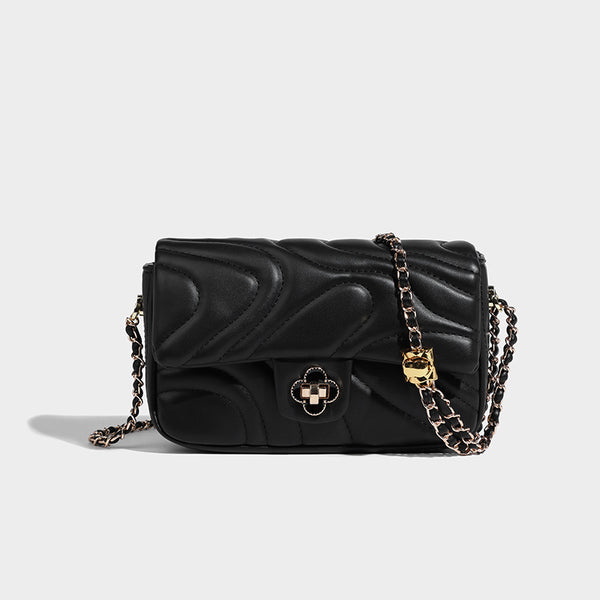 Compact cream quilted flap crossbody bag with wave stitching, gold-tone chain strap, and four-petal turn-lock clasp, detail