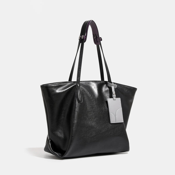 Large soft trapezoid tote bag with leather-look finish, dual shoulder straps, and gray hanging card tag, detail view 3