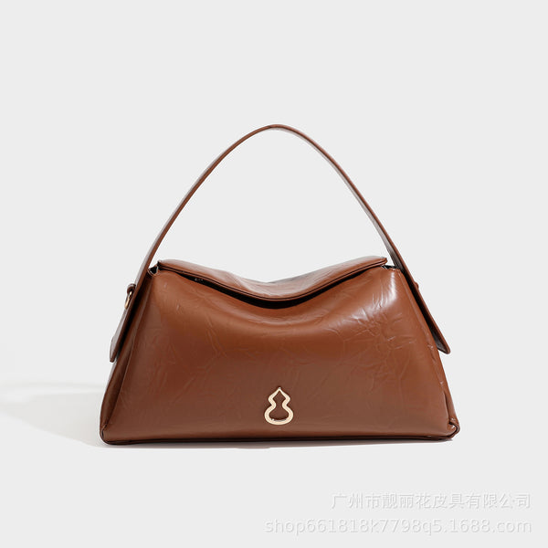 Glänzende, geknautschte Trapez-Schultertasche mit Klappenverschluss, Logo-Beschlägen in Goldoptik, Tragegriff und abnehmbarem, verstellbarem