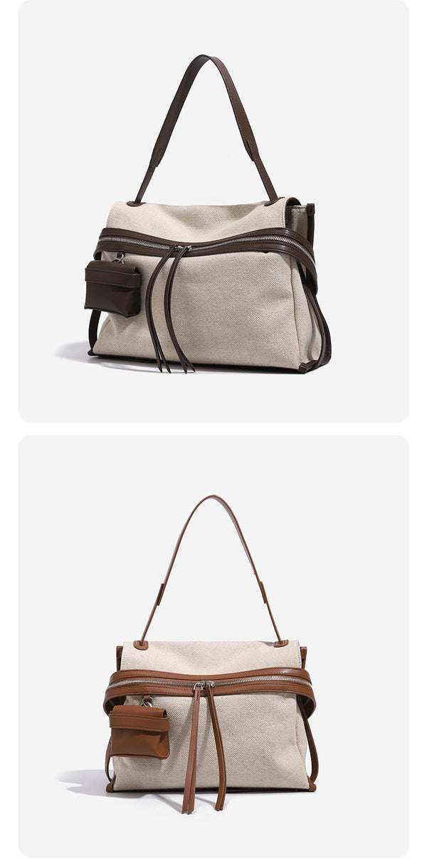 Cream canvas messenger shoulder bag with tan leather-look trim, dual zippers, tassel pulls, and attached mini front pouch