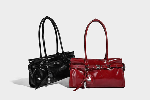 Structured rectangular glossy tote shoulder bag with belt buckle front strap and dangling charm hardware, detail view 14